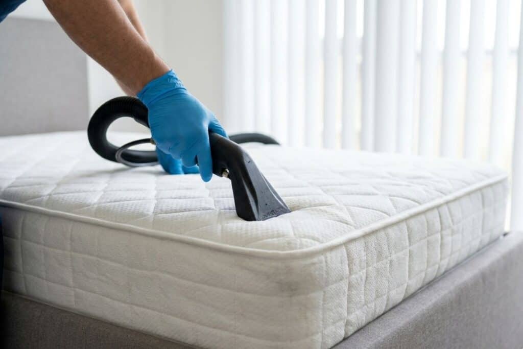 Professional technician deep cleaning a mattress to remove dust mites in Tulsa, OK